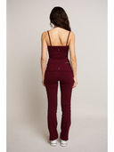 Woman wearing a burgundy set against a plain background